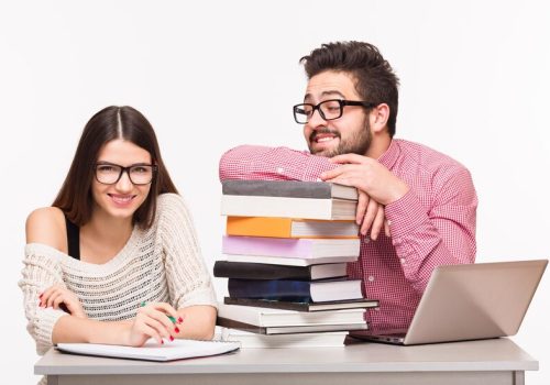 happy-students-sitting-table-preparing-exams-hppy-lady-looking-camera-her-groupmate-looking-her_549566-210